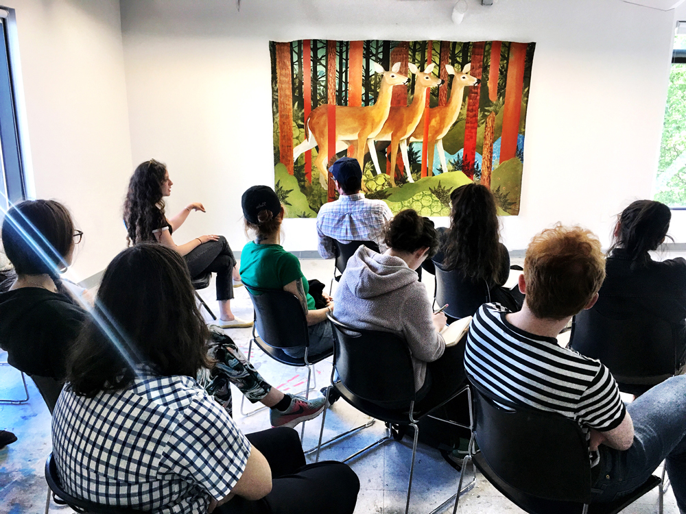 A PNCA class reviewing an image of three deer in a forest