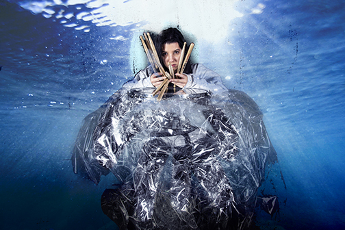 Rhythms Of Grace, figure holding drummer sticks, wrapped around foil, with an underwater background