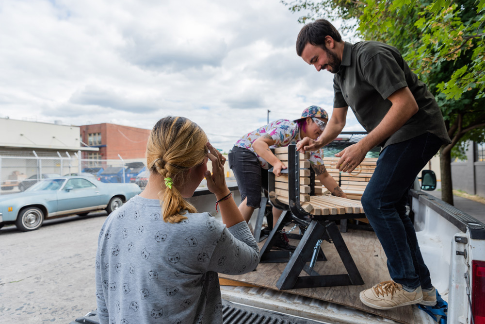 Artists unpack the new individual bench seats to be installed in Portland