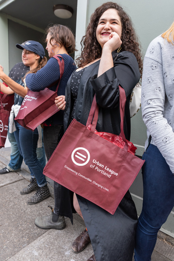 A person holding an Urban League of Portland tote around their arm