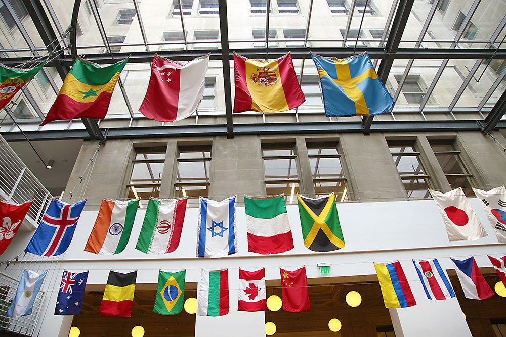 International Week flags in the Atrium at PNCA's main campus building looking through the skylight toward the tower