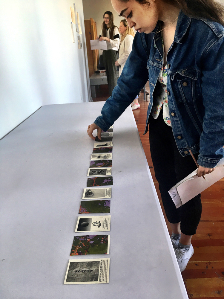 A person reviewing a lineup of tiles that comprise an art piece