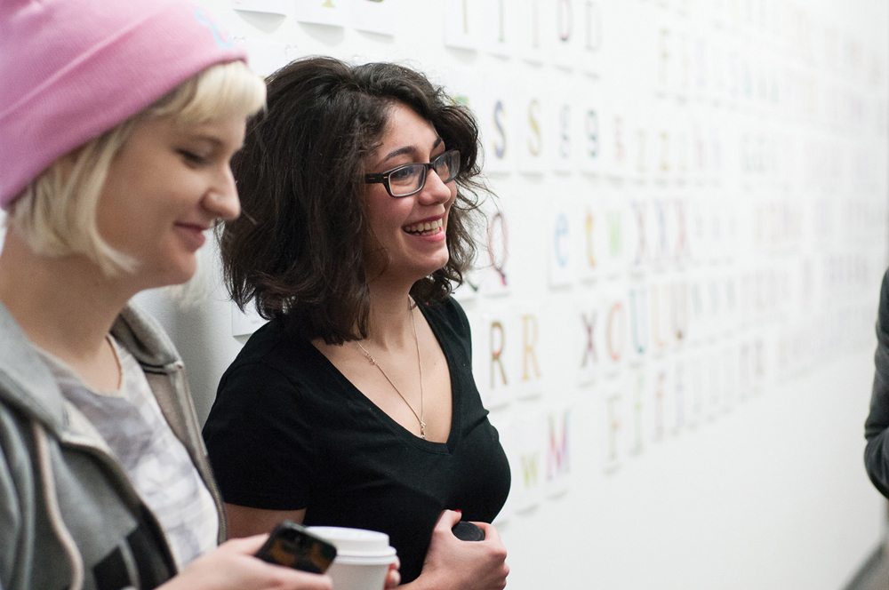 Two PNCA students standing across an art piece focused on fonts