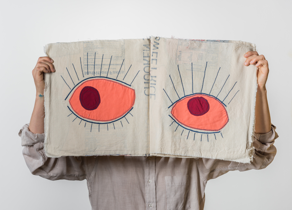 Book made of fabric open with large eyes on both pages, art by LK James