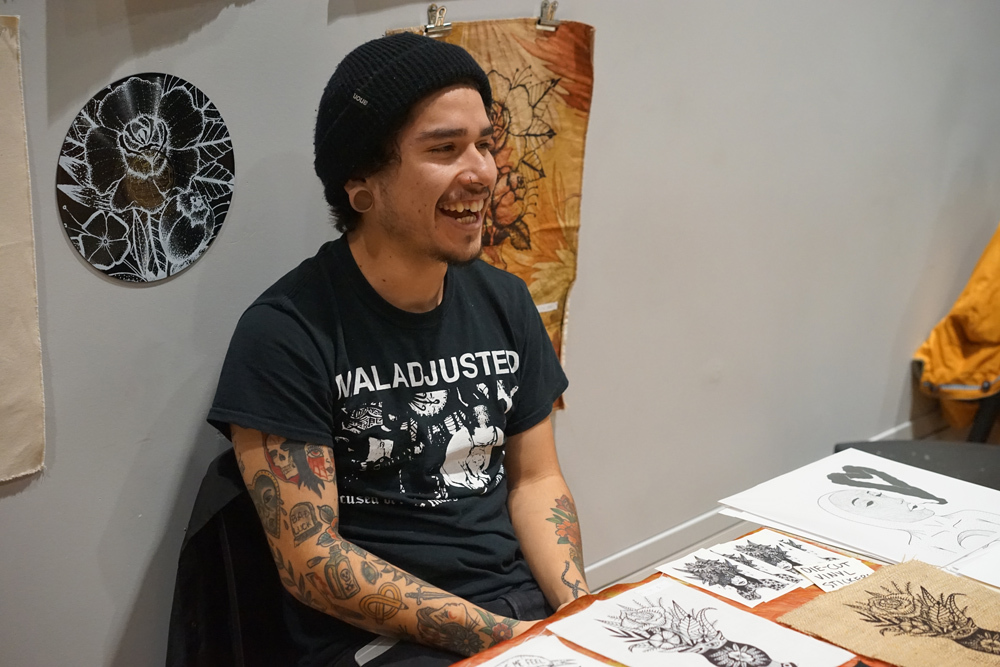 Club member laughing as they talk with other Pacific Northwest College of Art (PNCA) students about their school club.