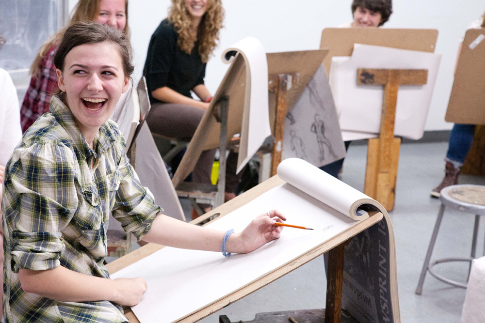 Laughing students working on projects in the drawing studio at Pacific Northwest College of Art (PNCA). 