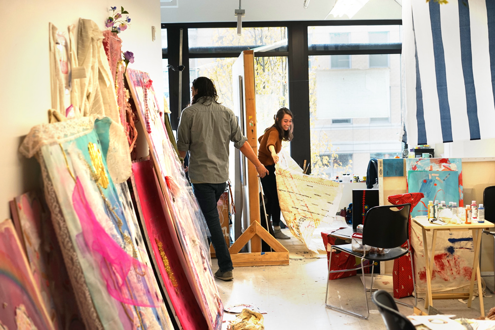Students Troy Mathews '16 and Addie Lehuauakea Fernandez '18 moving paintings in the Falcon Building Student Studios Pacific Northwest College of Art (PNCA).