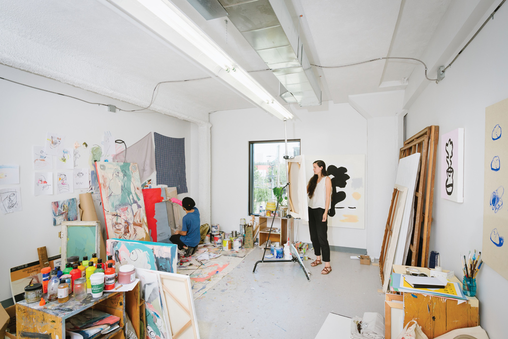 Two students working on paintings in the student studios at the Falcon Building of Pacific Northwest College of Art (PNCA). 