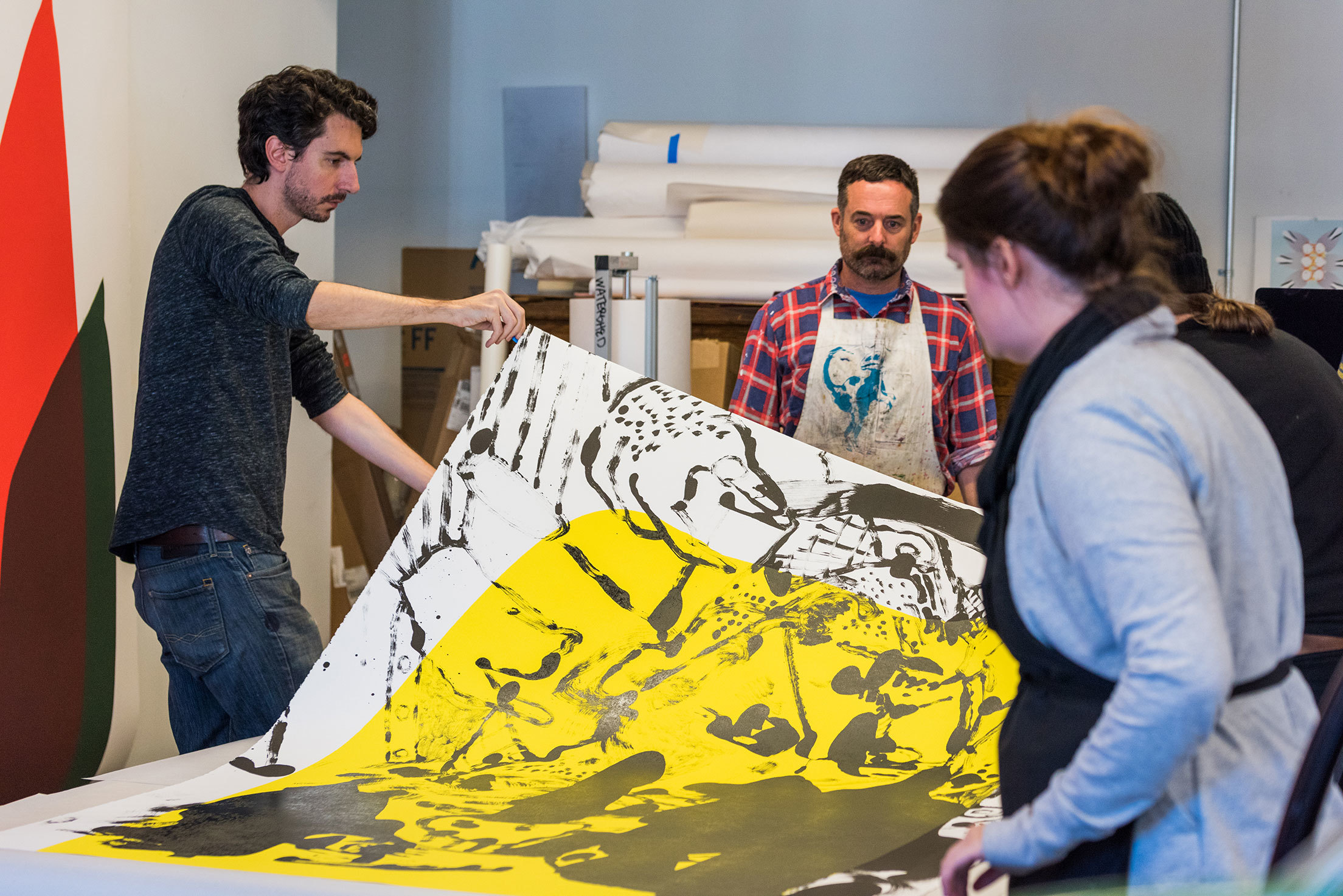 Storm Tharp and students of the MFA in Print Media program with a large-scale print in Watershed studio