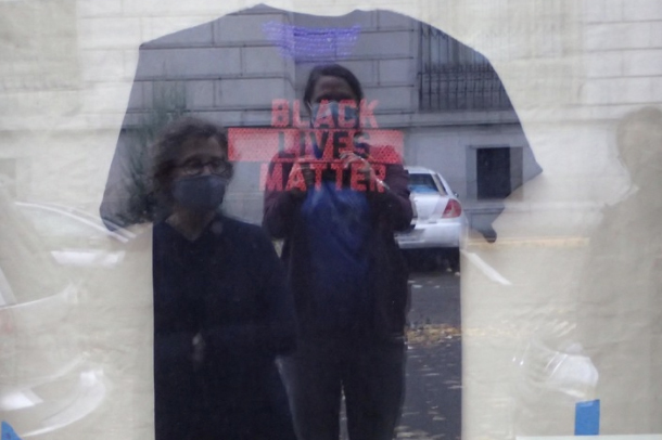 Sara Siestreem and another person taking a selfie in the reflection of a Black Lives Matter shirt